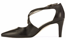 Side view of the Stella. A black leather high heel with two delicate straps that crisscross over the front. This two and a half inch heel has a pointed toe and two small buckles on the straps. Available in wide width and extra wide widths.